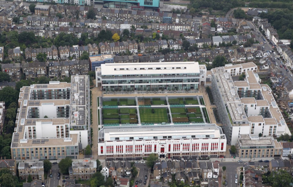 an aerial view of a large white building with a soccer field in front of it