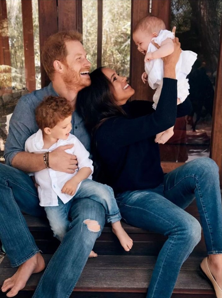 a family sitting on a porch holding a baby and smiling