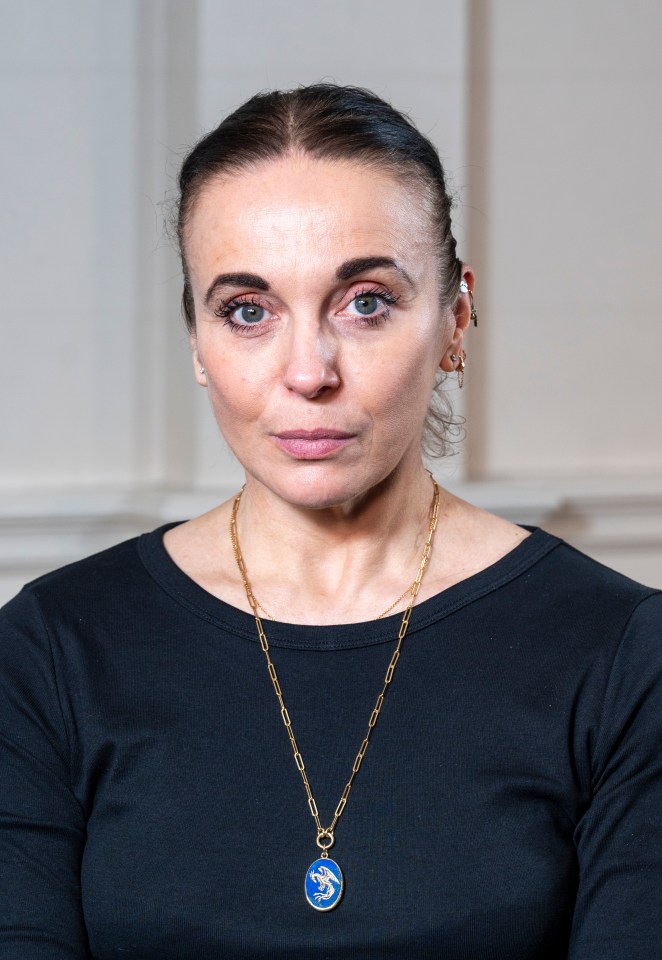 a woman wearing a black shirt and a gold chain necklace