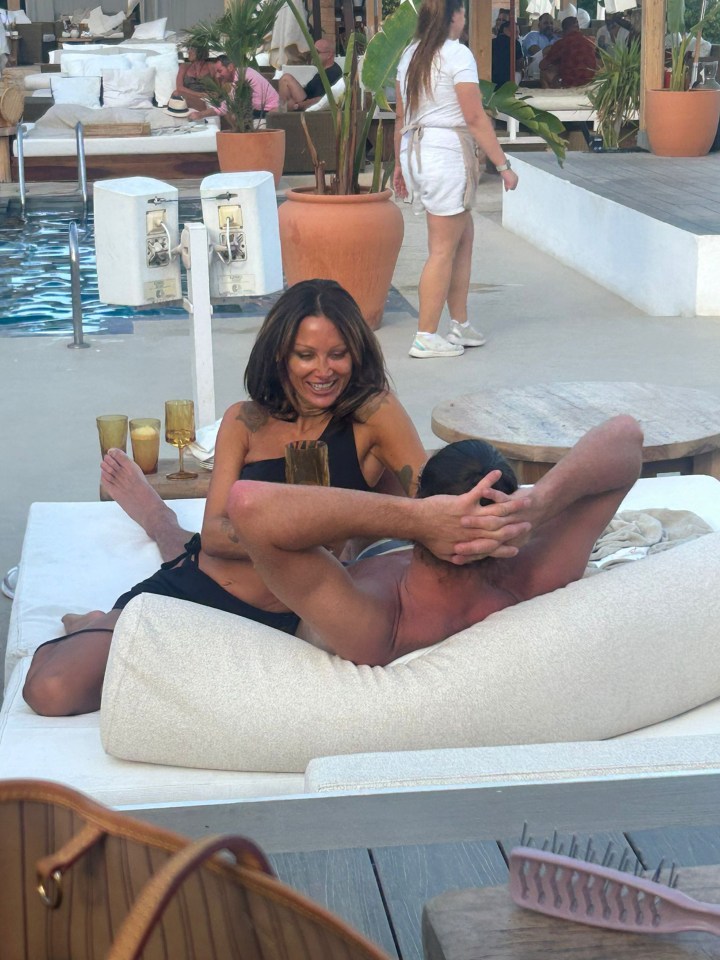 a woman sits next to a man on a lounge chair