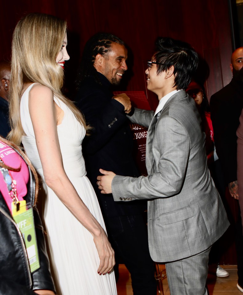 a man in a suit talks to a woman in a white dress