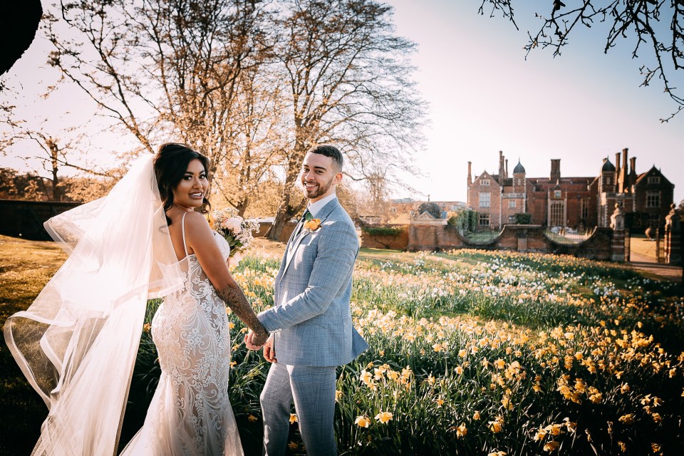 a bride and groom are posing for a picture in a field of flowers