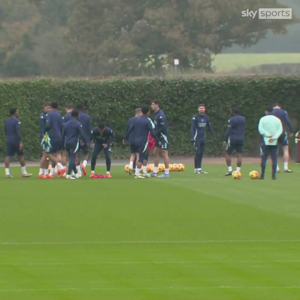 a group of soccer players on a field with sky sports in the background