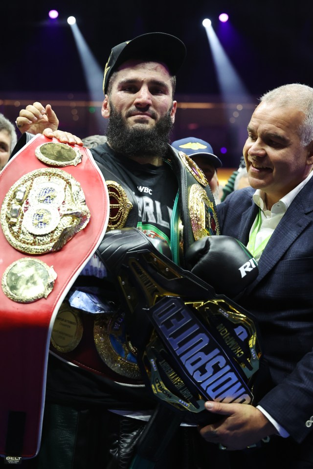 a man holds up a belt that says welterweight