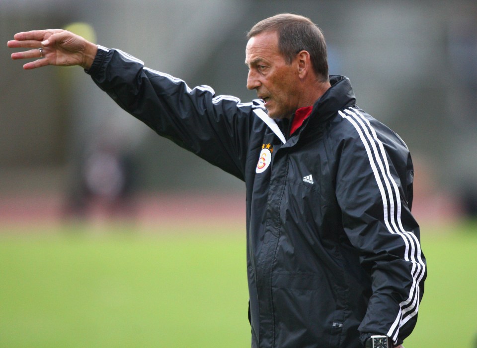 a man wearing an adidas jacket stands on a field