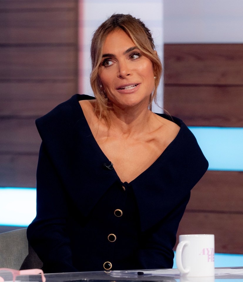 a woman sits at a table next to a cup that says " i am here "