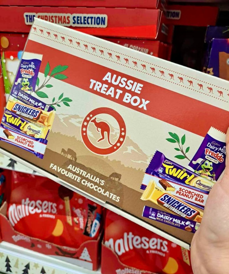 a person is holding a box of aussie treats