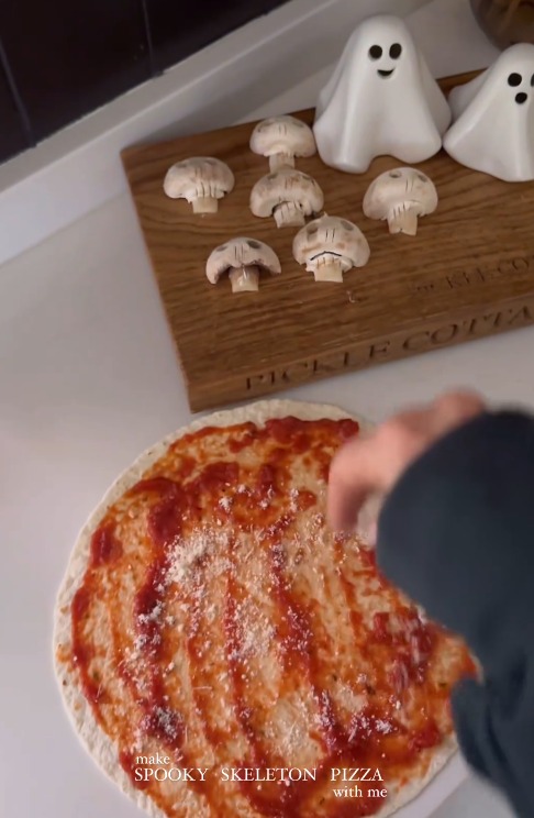 a person is making a spooky skeleton pizza