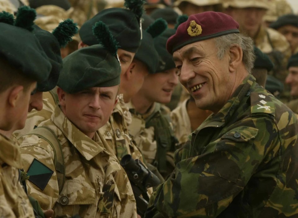 a group of soldiers are standing in front of a man wearing a red beret