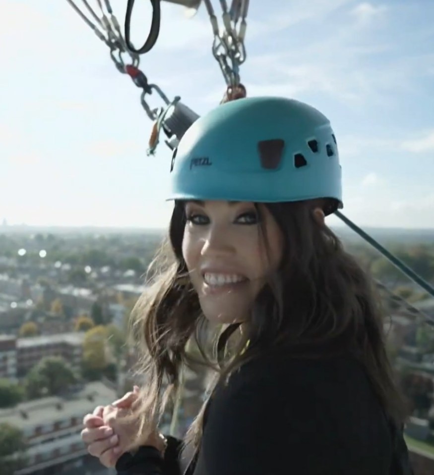 a woman wearing a blue petzl helmet smiles