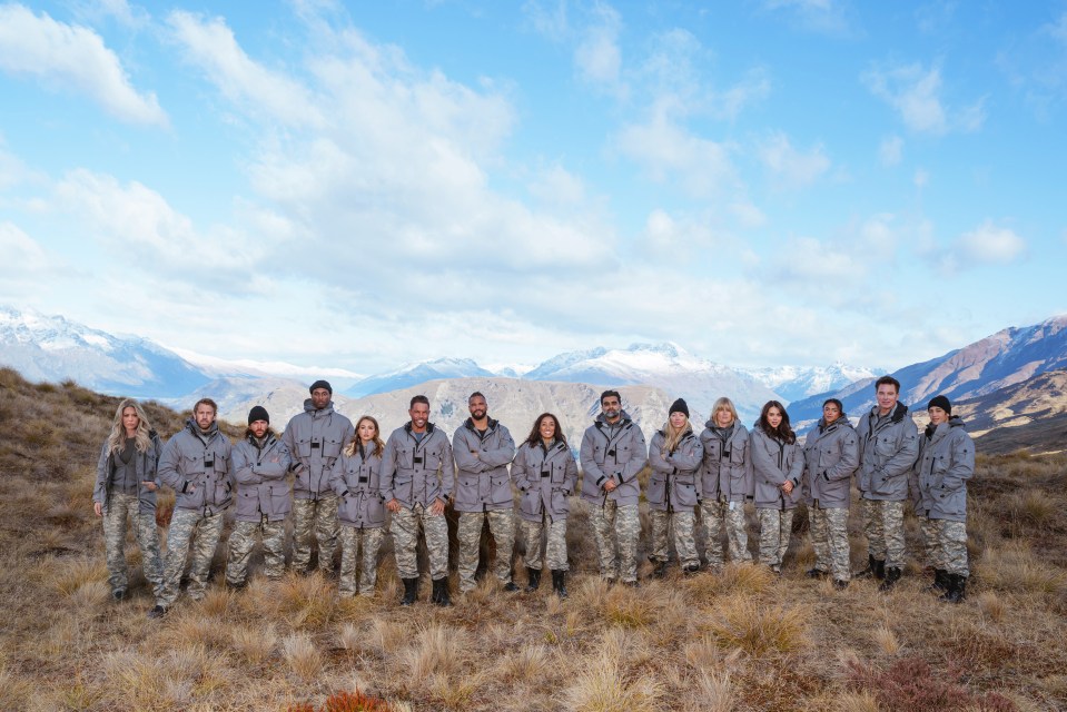 a group of people standing in a field with mountains in the background