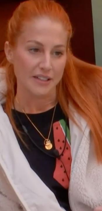 a woman with red hair is wearing a watermelon t-shirt and a necklace .