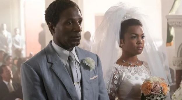 a bride and groom are standing next to each other in a church .