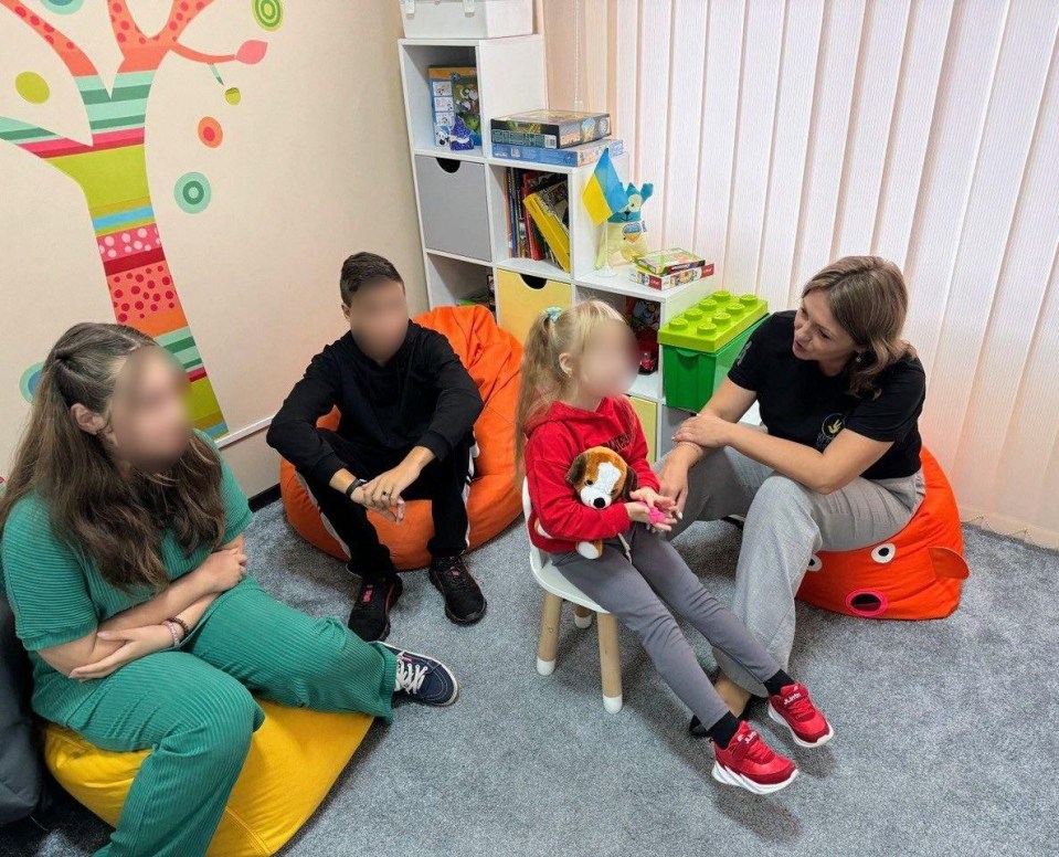 a girl in a red sweatshirt sits on a bean bag chair