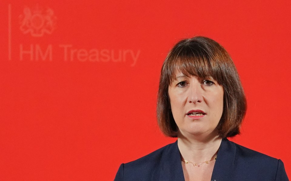 a woman stands in front of a red background that says hm treasury