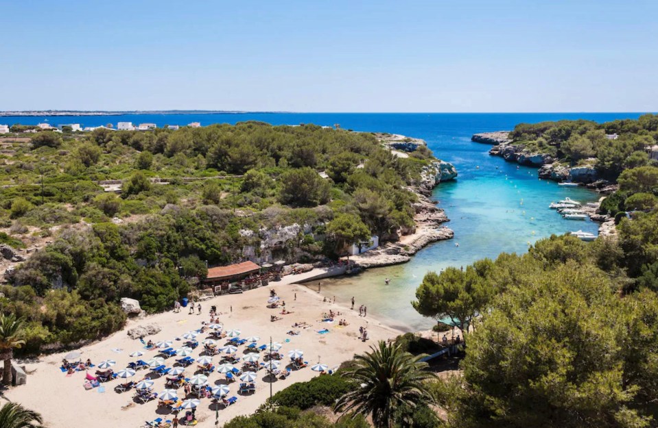 an aerial view of a beach with lots of chairs and umbrellas