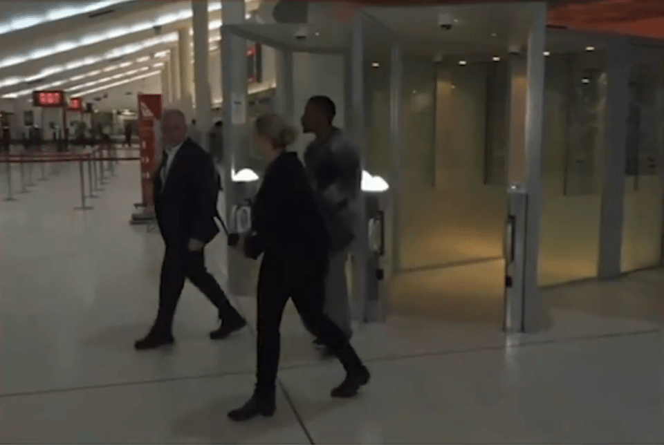 Footage showed him being led through an airport in handcuffs