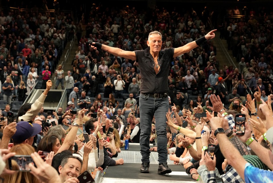 a man stands in front of a crowd with his arms outstretched