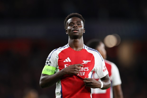 a soccer player wearing a red jersey that says fly emirates on it