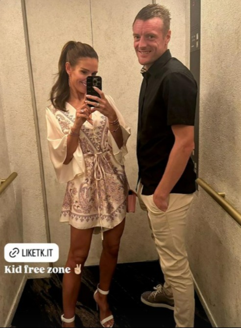 a woman taking a picture of herself in an elevator next to a man