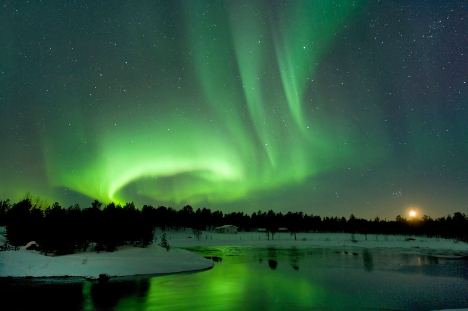 the aurora borealis shines brightly over a frozen lake