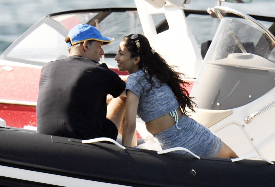 a man in a blue hat sits next to a woman on a boat