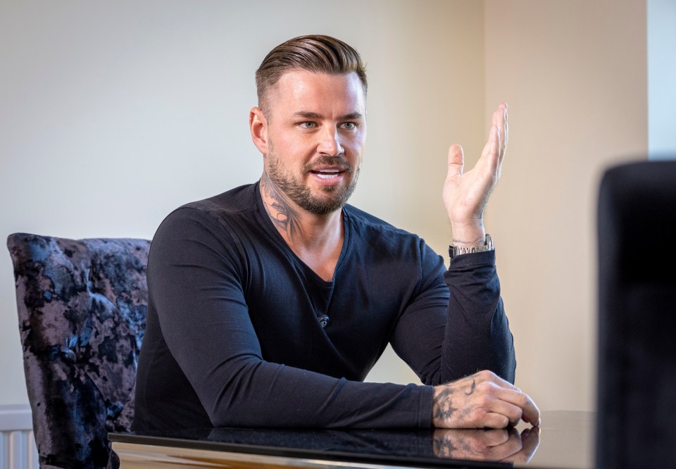 a man with a tattoo on his arm is sitting at a table