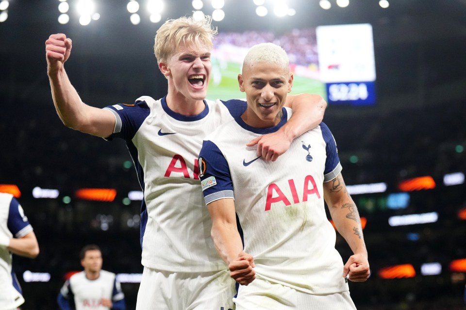 two soccer players wearing aia jerseys celebrate a goal