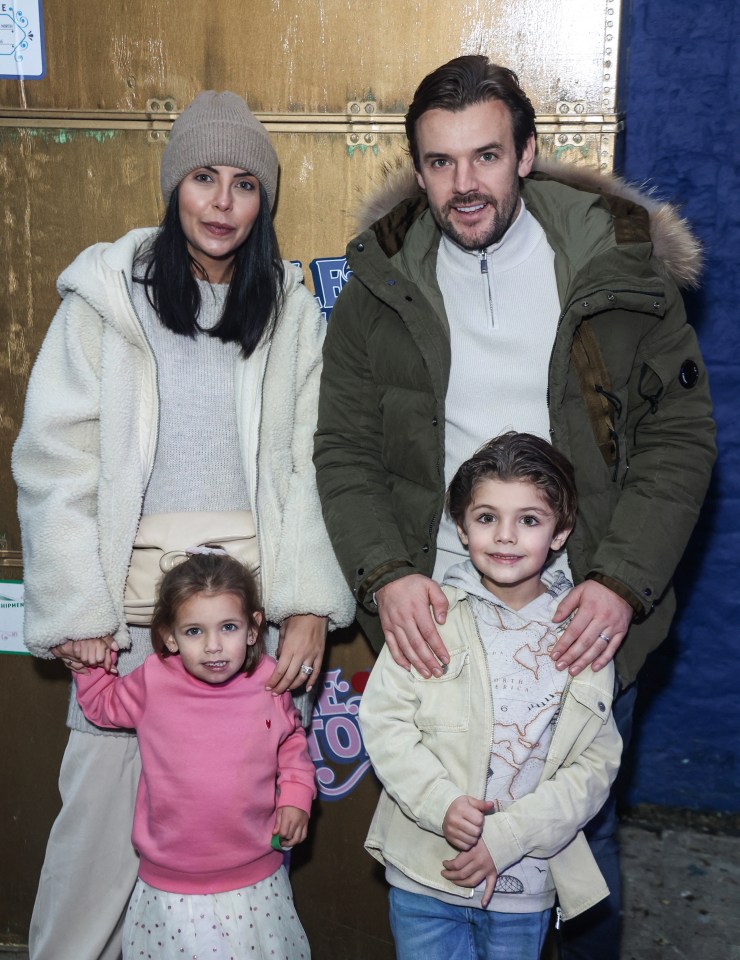 a family posing for a picture in front of a sign that says ' ice cream ' on it