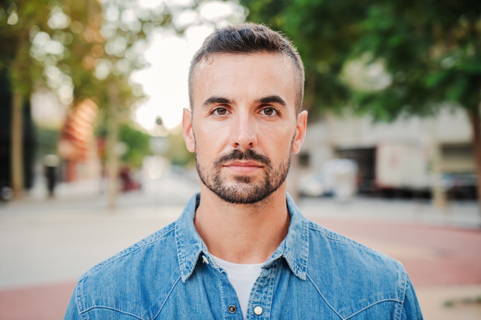 a man with a beard is wearing a blue shirt