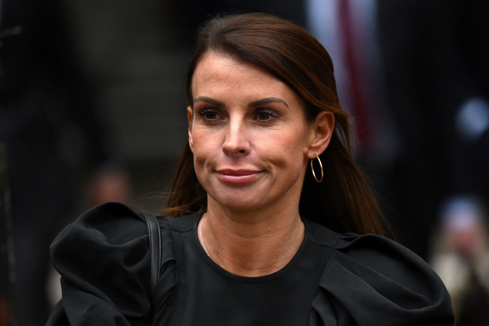 a woman wearing a black top and gold hoop earrings