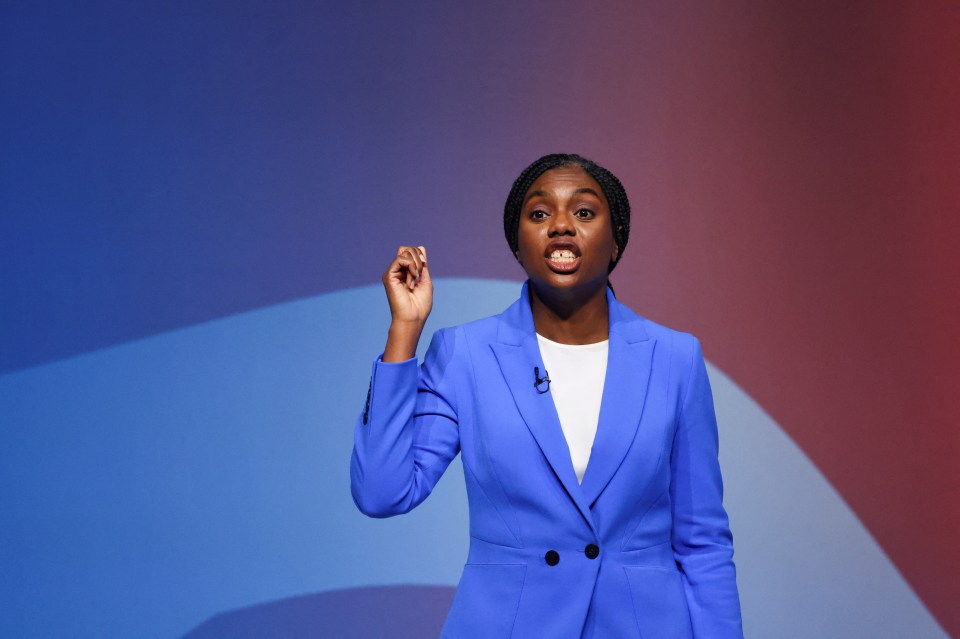 a woman in a blue jacket is giving a speech