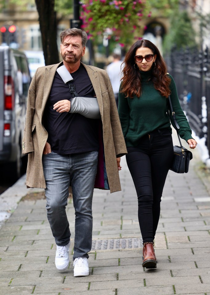 a man with a broken arm walks with a woman