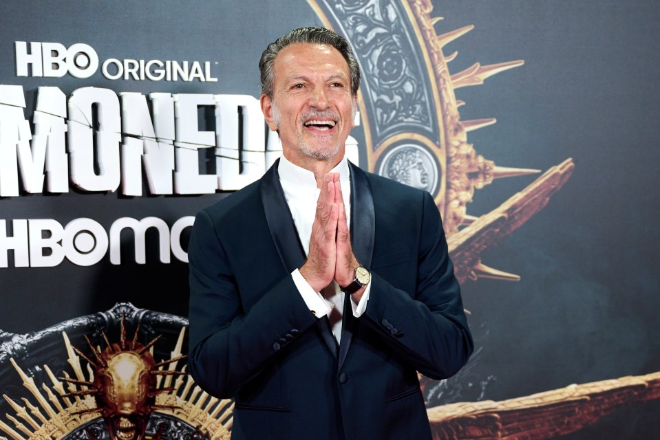 a man stands in front of a sign that says hbo original