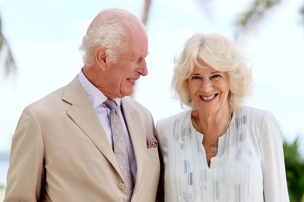 a man in a suit and tie stands next to a woman in a white dress