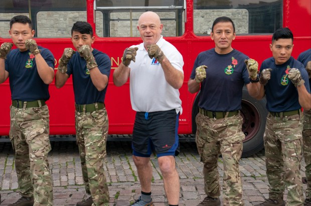 a group of soldiers are standing in front of a red bus