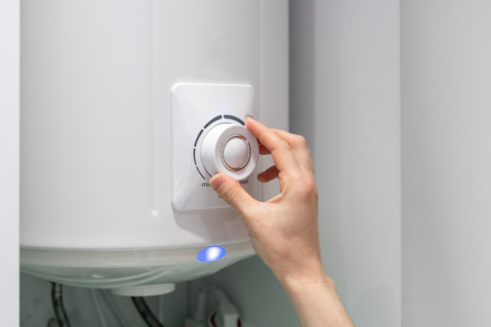 a person is adjusting the temperature of a water heater