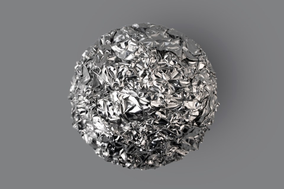 a ball made of crumpled aluminum foil on a gray background