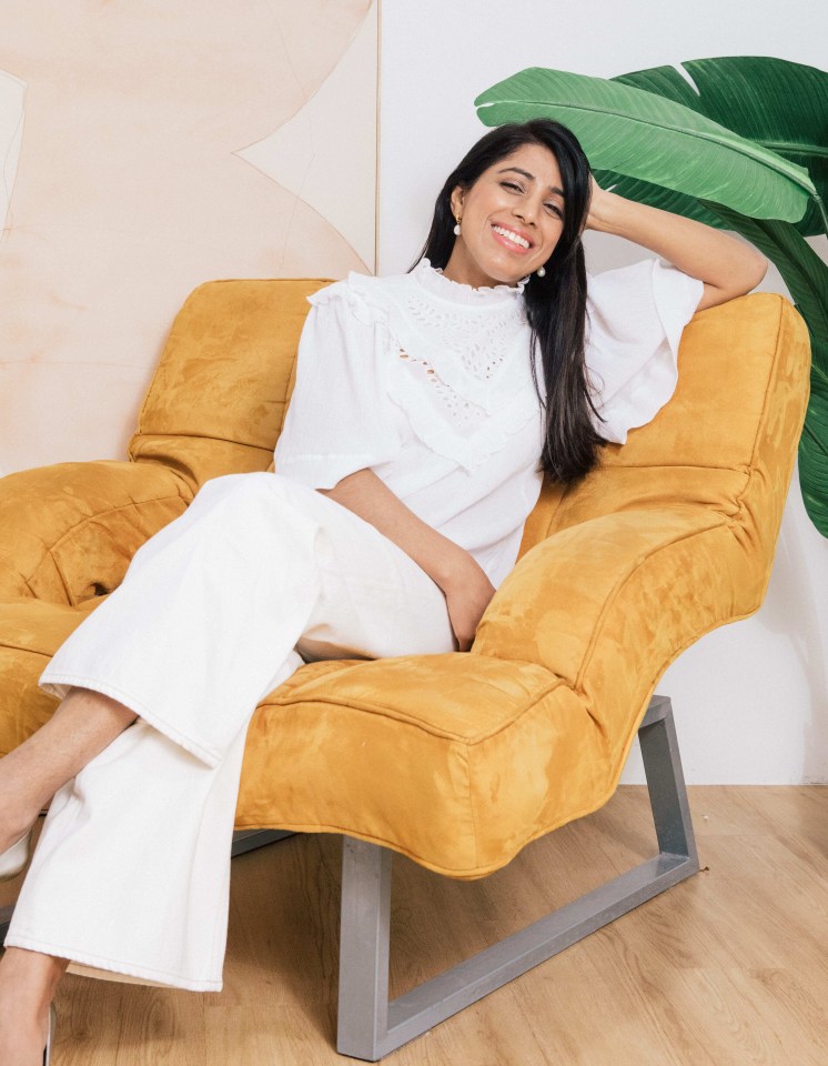 a woman in a white shirt sits in a yellow chair