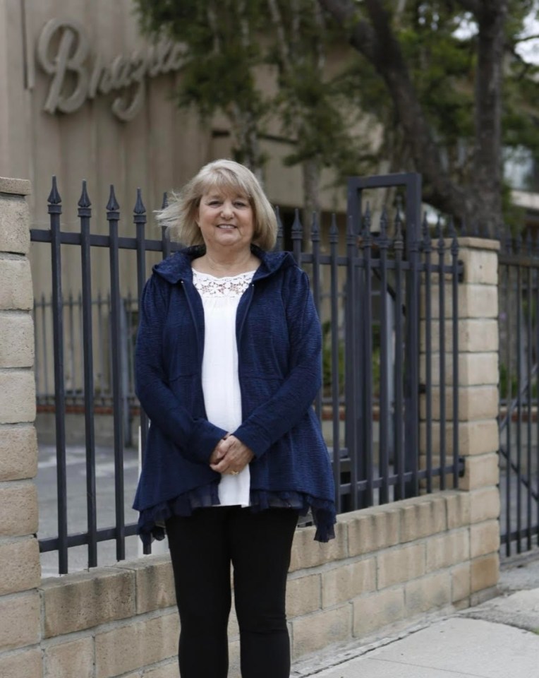 a woman stands in front of a building that says bragie