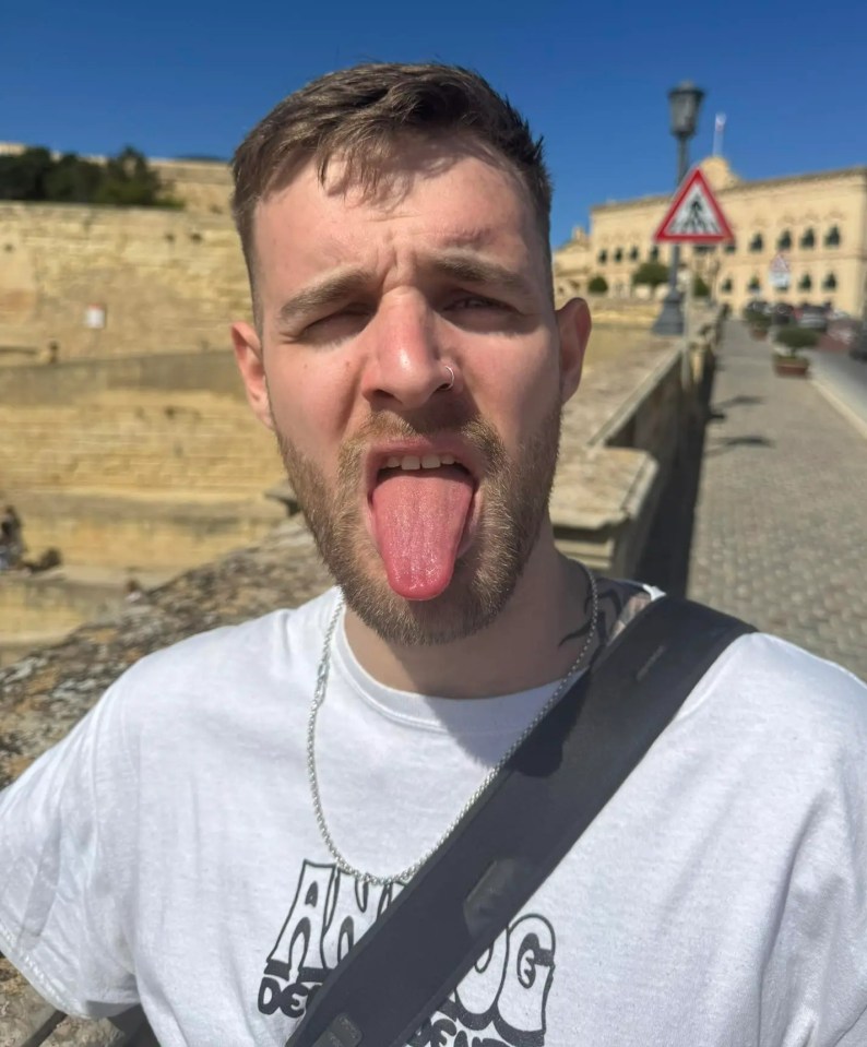 a man wearing a white shirt that says always sticking his tongue out