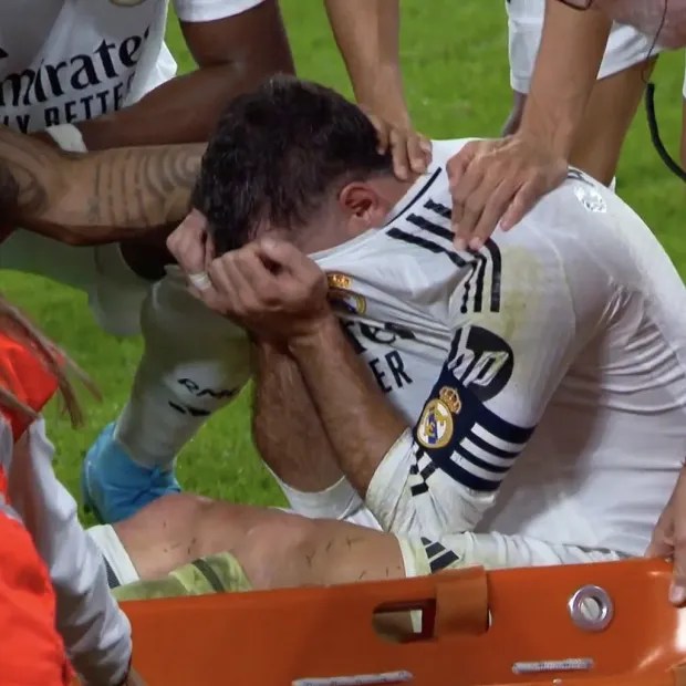 a soccer player is laying on a stretcher with emirates written on his shirt