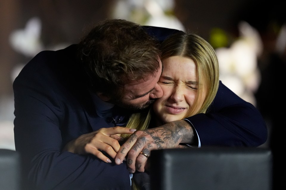 a man with a tattoo on his arm kisses a woman on the cheek