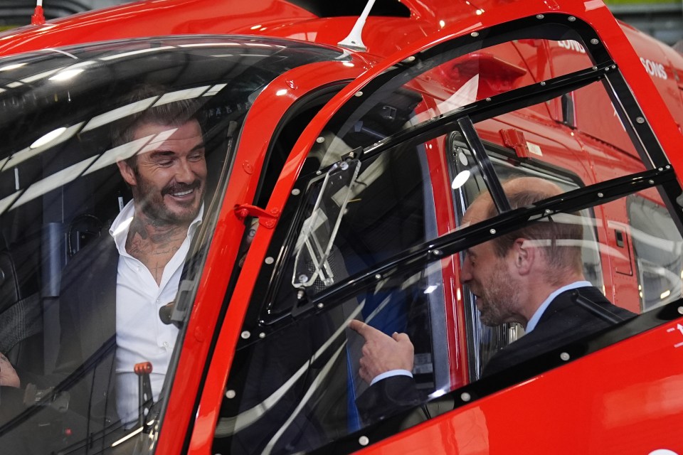 a man with a tattoo on his chest sits in a red helicopter