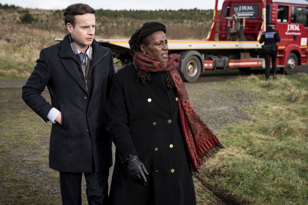 a man and a woman are walking in front of a j.w.a.l. tow truck