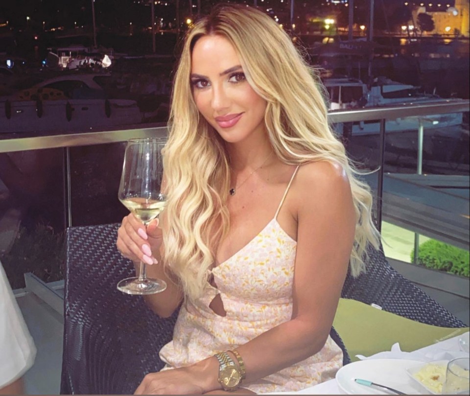 a woman sitting at a table holding a glass of wine