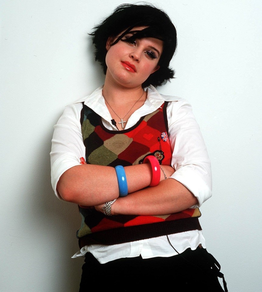 a woman with her arms crossed wearing a vest with a monkey on it