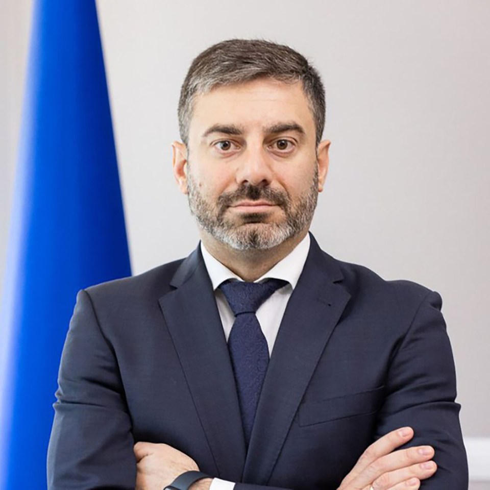 a man in a suit and tie with his arms crossed