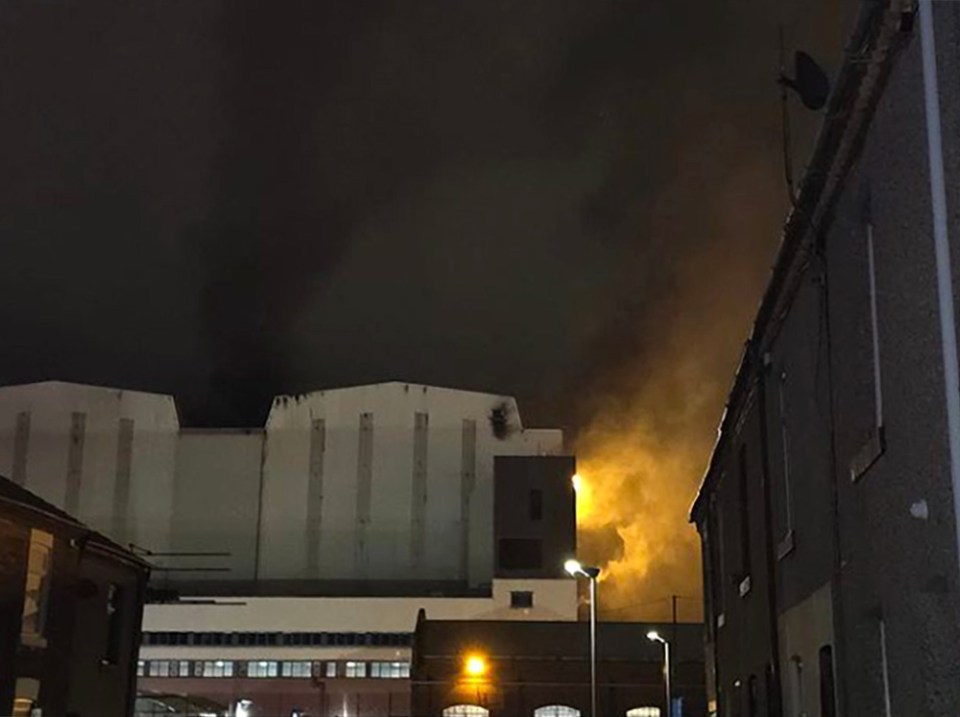 a large building with smoke coming out of it at night