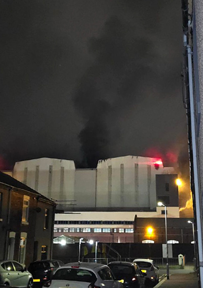 a building with smoke coming out of it at night